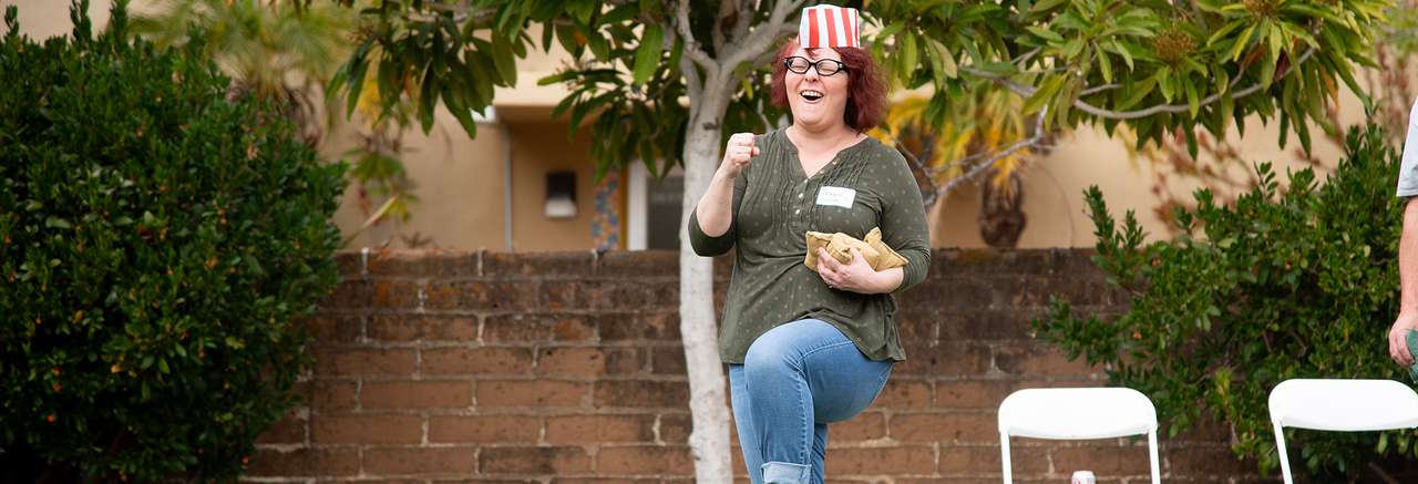 Cal Poly Partners employee celebrating while playing cornhole.