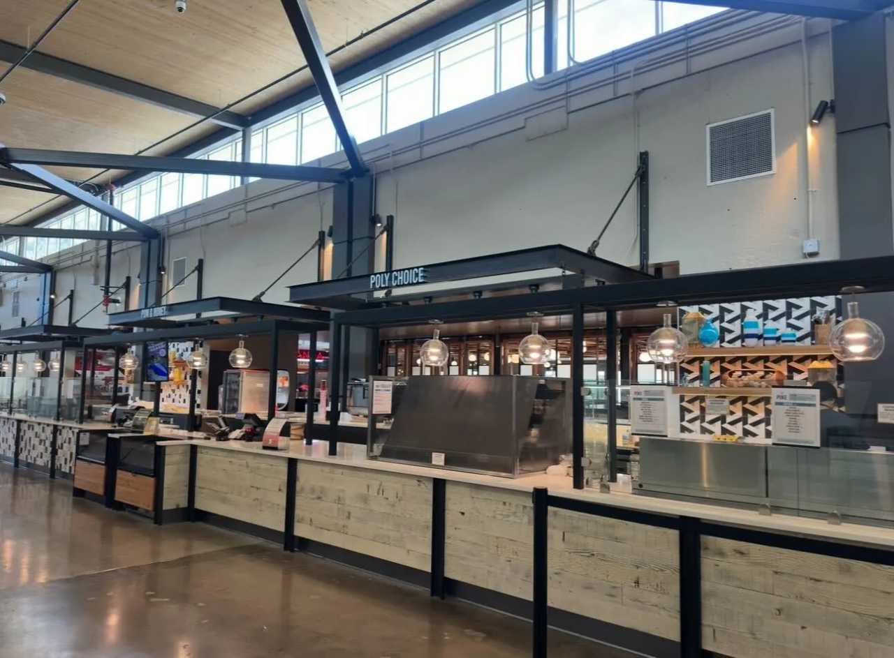 The Poly Choice dining venue at Cal Poly’s 1901 Marketplace, featuring a clean, modern counter setup with hanging lights, menu boards and food stations.